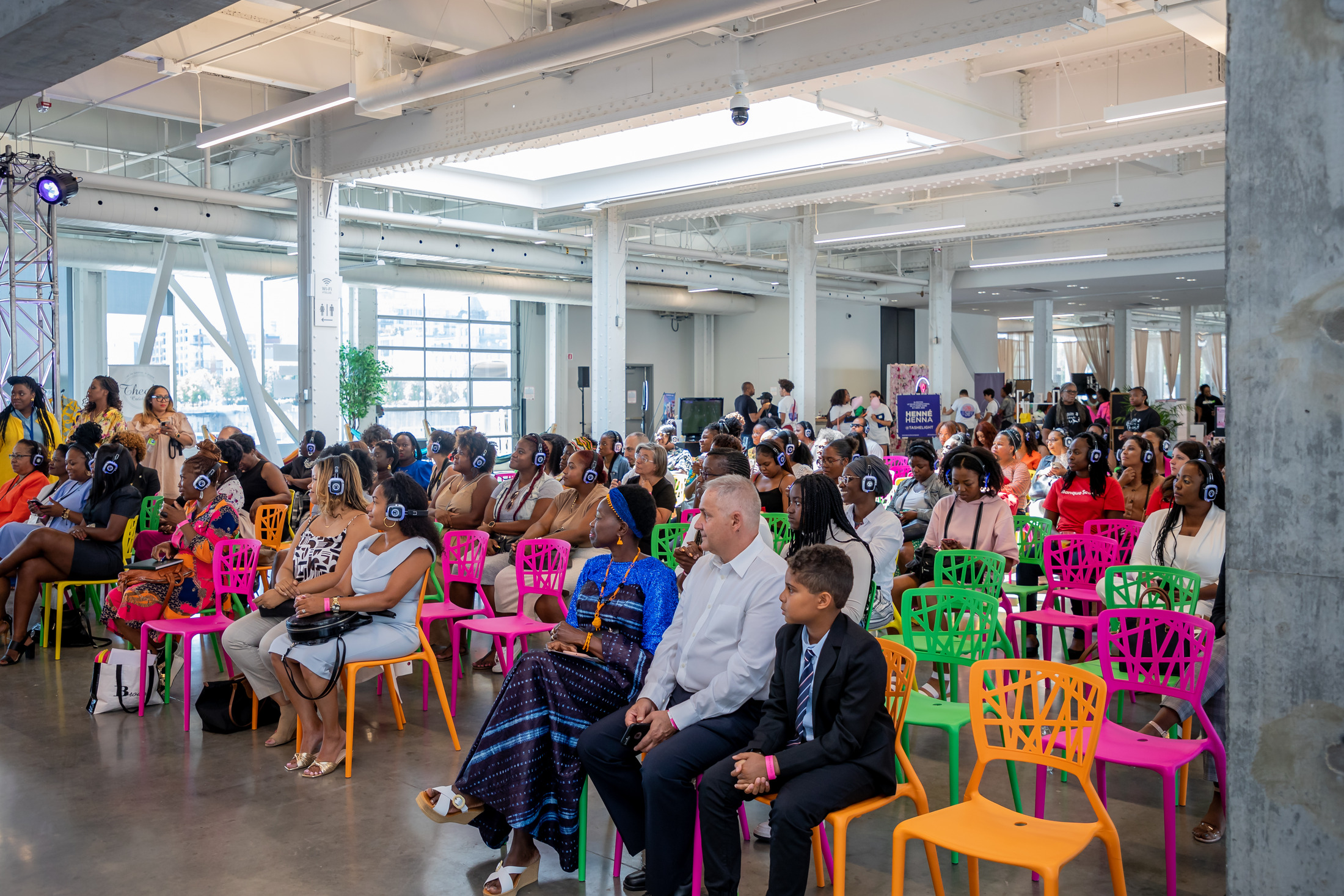 Guests seated in a bright open event hall during a conference