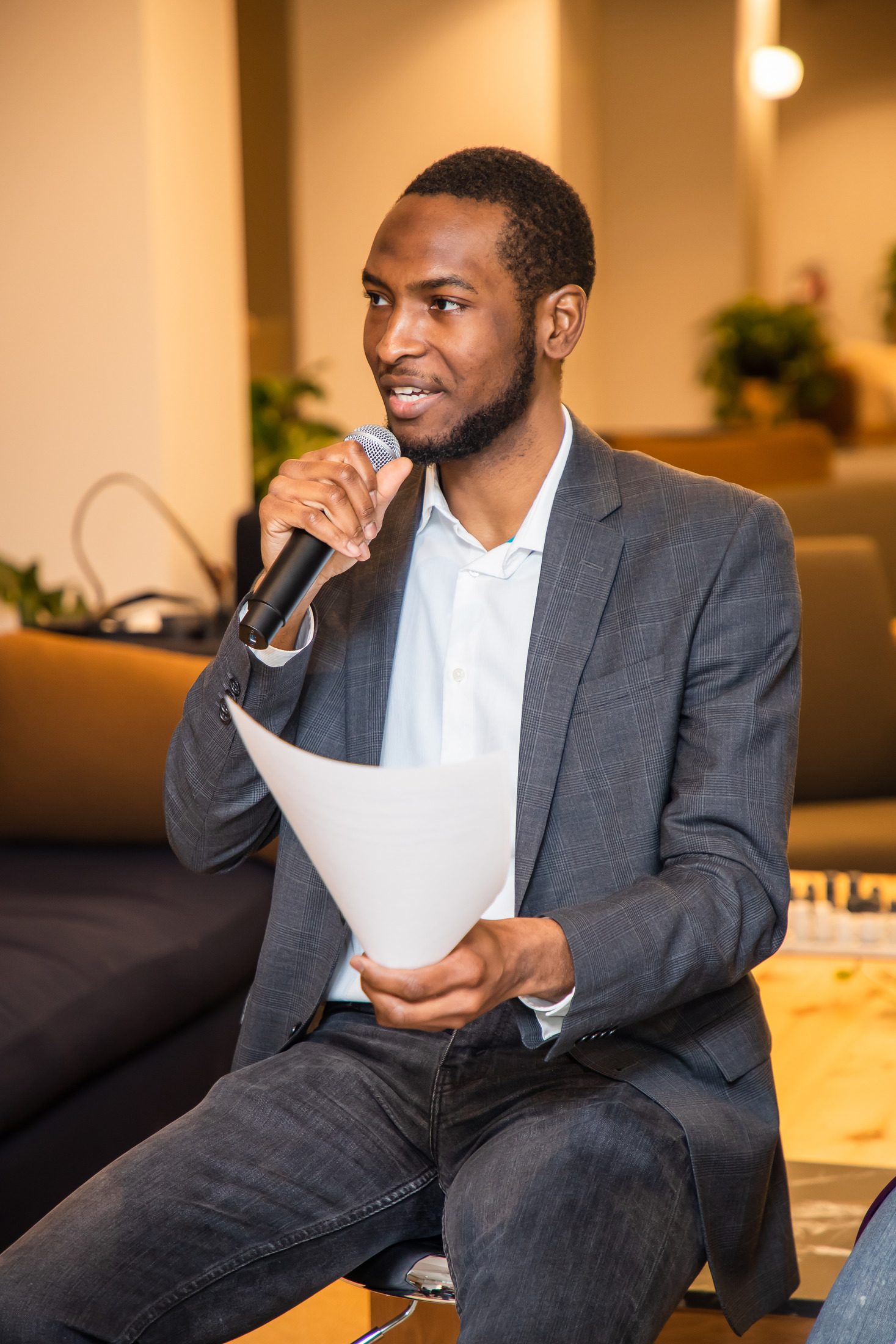 Speaker holding notes and a microphone during a panel event