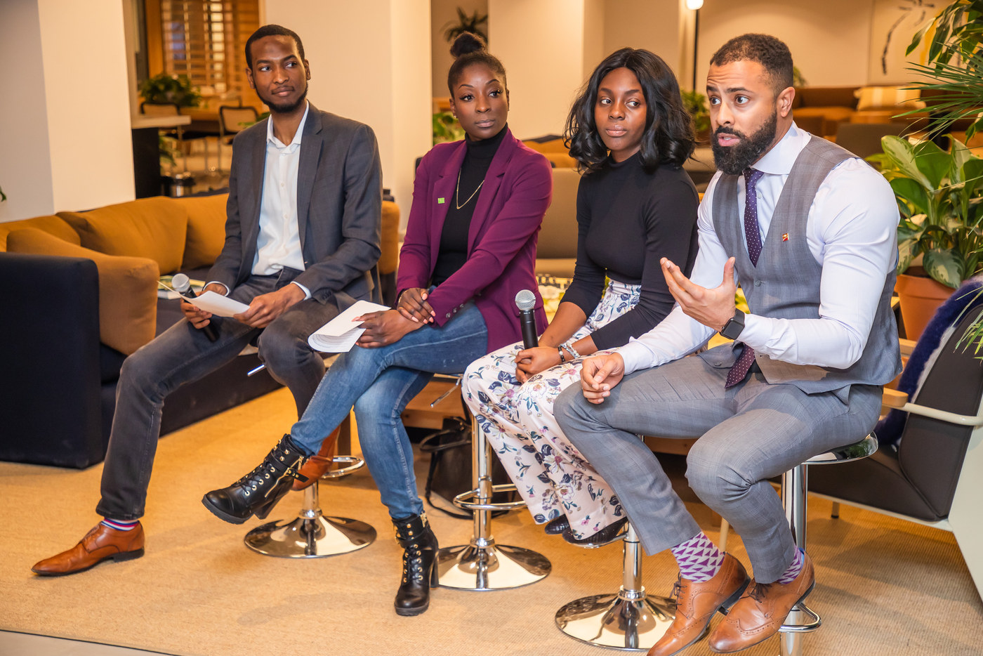 Four panellists seated on stools in conversation